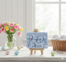 Load image into Gallery viewer, Intricate handmade soap scene from Soap Simple Creations featuring an Easter bunny, chicks, and tulips, displayed on a wooden easel with spring flowers. Vegan and cruelty free soap.