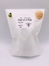 Load image into Gallery viewer, Handmade vegan soaps featuring a gorgeous bee and honeycomb design soap on a rope. crafted with natural French clays, activated charcoal and essential oils. a eco-friendly, zero waste gift that’s cruelty-free, skin-nourishing, and perfect for bee lovers and gifting. UK Small Business