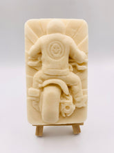 Load image into Gallery viewer, detailed handmade vegan soap gift featuring a motorcycle rider with a skull emblem on their jacket, displayed on a wooden easel against a whimsical farmhouse decor background
