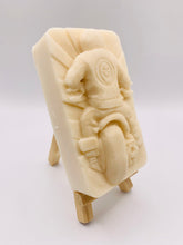 Load image into Gallery viewer, detailed handmade vegan soap gift featuring a motorcycle rider with a skull emblem on their jacket, displayed on a wooden easel against a whimsical farmhouse decor background