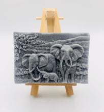 Load image into Gallery viewer, Handmade vegan soap featuring an elephant family with baby elephant and packed in beautiful eco friendly packaging. crafted with natural French clays, activated charcoal and essential oils. a eco-friendly, zero waste gift that’s cruelty-free, skin-nourishing, and perfect for elephant lovers or animal themed gifts. Small business UK