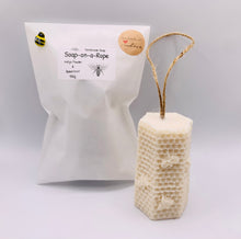 Load image into Gallery viewer, Handmade vegan soaps featuring a gorgeous bee and honeycomb design soap on a rope. crafted with natural French clays, activated charcoal and essential oils. a eco-friendly, zero waste gift that’s cruelty-free, skin-nourishing, and perfect for bee lovers and gifting. UK Small Business
