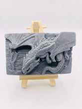Load image into Gallery viewer, Our Flying Dragon soap features a striking dragon with its majestic wings spread wide, symbolising freedom and power. This artisan bar is vegan, cruelty-free, and designed with care for both your skin and the planet. Available in your choice of colour and essential oil. Each soap comes beautifully wrapped in eco