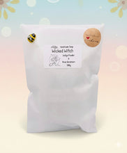 Load image into Gallery viewer, A beautiful handmade vegan soap featuring a detailed image of a witch flying on a broomstick past a crescent moon and owls, displayed on a wooden easel against a whimsical farmhouse decor background.