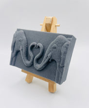 Load image into Gallery viewer, Handmade vegan soaps featuring two elephants who's trunks meet in a heart shape packed in beautiful eco friendly packaging. crafted with natural French clays, activated charcoal and essential oils. a eco-friendly, zero waste gift thatās cruelty-free, skin-nourishing, and perfect for elephant lovers or animal themed gifts. Small business UK
