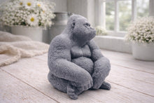 Load image into Gallery viewer, A highly detailed handmade vegan soap in a natural stone-grey colour, sculpted in the shape of a sitting gorilla with realistic fur and muscle textures, displayed on a light wooden surface.