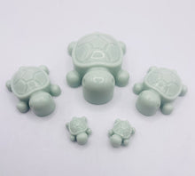 Load image into Gallery viewer, Handmade vegan soaps featuring a set of 5 turtle family soaps and gift boxed in beautiful eco friendly packaging crafted with natural French clays, activated charcoal and essential oils. a eco-friendly, zero waste gift that’s cruelty-free, skin-nourishing, and perfect for turtle lovers and animal themed gifts. small business UK