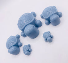 Load image into Gallery viewer, Handmade vegan soaps featuring a set of 5 turtle family soaps and gift boxed in beautiful eco friendly packaging crafted with natural French clays, activated charcoal and essential oils. a eco-friendly, zero waste gift that’s cruelty-free, skin-nourishing, and perfect for turtle lovers and animal themed gifts. small business UK
