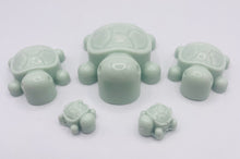 Load image into Gallery viewer, Handmade vegan soaps featuring a set of 5 turtle family soaps and gift boxed in beautiful eco friendly packaging crafted with natural French clays, activated charcoal and essential oils. a eco-friendly, zero waste gift that’s cruelty-free, skin-nourishing, and perfect for turtle lovers and animal themed gifts. small business UK
