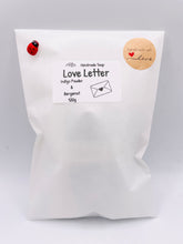 Load image into Gallery viewer, Handmade vegan soaps featuring a boy and girl sat on a bench with the wording Love Is... , in beautiful eco friendly packaging. crafted with natural French clays, activated charcoal and essential oils. a eco-friendly, zero waste gift that’s cruelty-free, skin-nourishing, the perfect gift for Valentines day or anniversary gift. small business UK