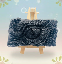 Load image into Gallery viewer, dragon Gift | dragon eye gift, dino gift, alternative gift, Dragon / Dinosaur Eye Vegan Soap Wooden display easels are available to purchase on a separate listing Calling all fantasy lovers! Step into a realm of mystical charm with our captivating dragon / dinosaur eye soap. This soap is vegan, cruelty free and available in your choice of colour and essential oil. All our soaps are made with natural clays and essential oils to gently cleanse and nourish your skin. eco conscious gift