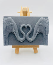 Load image into Gallery viewer, Handmade vegan soaps featuring two elephants who's trunks meet in a heart shape packed in beautiful eco friendly packaging. crafted with natural French clays, activated charcoal and essential oils. a eco-friendly, zero waste gift thatās cruelty-free, skin-nourishing, and perfect for elephant lovers or animal themed gifts. Small business UK