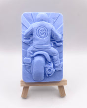 Load image into Gallery viewer, detailed handmade vegan soap gift featuring a motorcycle rider with a skull emblem on their jacket, displayed on a wooden easel against a whimsical farmhouse decor background