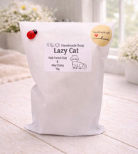 Load image into Gallery viewer, White bag of 'Lazy Cat' handmade soap with a label on a light wooden surface.
