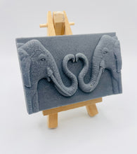 Load image into Gallery viewer, Handmade vegan soaps featuring two elephants who's trunks meet in a heart shape packed in beautiful eco friendly packaging. crafted with natural French clays, activated charcoal and essential oils. a eco-friendly, zero waste gift thatās cruelty-free, skin-nourishing, and perfect for elephant lovers or animal themed gifts. Small business UK