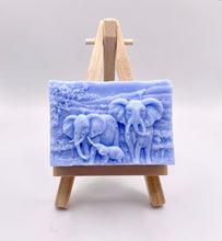 Load image into Gallery viewer, Handmade vegan soap featuring an elephant family with baby elephant and packed in beautiful eco friendly packaging. crafted with natural French clays, activated charcoal and essential oils. a eco-friendly, zero waste gift that’s cruelty-free, skin-nourishing, and perfect for elephant lovers or animal themed gifts. Small business UK