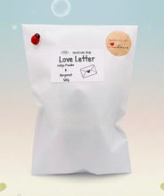 Load image into Gallery viewer, Handmade vegan soaps featuring a boy and girl sat on a bench with the wording Love Is... , in beautiful eco friendly packaging. crafted with natural French clays, activated charcoal and essential oils. a eco-friendly, zero waste gift that’s cruelty-free, skin-nourishing, the perfect gift for Valentines day or anniversary gift. small business UK