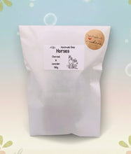 Load image into Gallery viewer, A grey and white handmade vegan soap featuring a highly detailed relief of two horses nuzzling heads, displayed on a wooden easel against a whimsical farmhouse decor background.