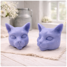 Load image into Gallery viewer, two handmade vegan soaps in the shape of Siamese cat heads, featuring elegant pointed ears and sleek facial features, displayed on a neutral cloth in a bright farmhouse decor setting.