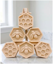 Load image into Gallery viewer, A handmade vegan soap gift set featuring six hexagonal bars stacked in a pyramid on a small wooden easel; some bars show a honeybee relief and others a honeycomb pattern