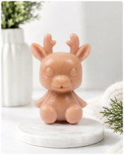 Load image into Gallery viewer, A 3D handmade vegan soap crafted into a cute, sitting baby reindeer with small antlers, rounded features, and a sweet expression, set against a bright farmhouse window.