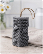 Load image into Gallery viewer, A tall, rectangular handmade vegan soap with a detailed honeycomb texture on all sides and small embossed bees, featuring a natural twine hanging rope, displayed upright on a light wooden surface.