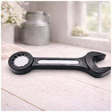 Load image into Gallery viewer, A 3D handmade vegan soap sculpted in the shape of a realistic spanner or wrench tool, finished in a sleek charcoal black with silver-painted detailing on the handle and head, lying on a light wood surface.