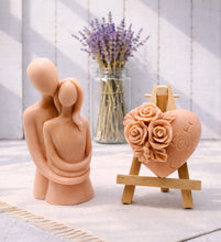 Load image into Gallery viewer, This gift set features a stunning soap sculpture of a man gently embracing a woman alongside a charming rose-adorned heart soap, stamped with the heartfelt message "I LOVE U".