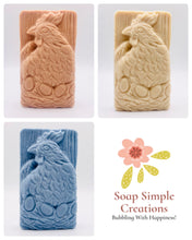 Load image into Gallery viewer, Handmade vegan soaps featuring a chicken sat on her nest of eggs, in beautiful eco friendly packaging. crafted with natural French clays, activated charcoal and essential oils. a eco-friendly, zero waste gift that’s cruelty-free, skin-nourishing, the perfect gift for easter and animal lovers. small business UK
