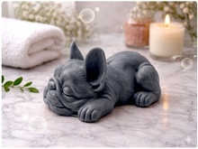 Load image into Gallery viewer, Handmade vegan soap in the shape of a realistic sleeping French Bulldog lying down, showing detailed ear texture and facial wrinkles, surrounded by bubbles in a marble bathroom setting.