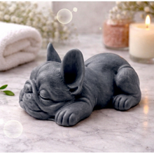 Load image into Gallery viewer, Handmade vegan soap in the shape of a realistic sleeping French Bulldog lying down, showing detailed ear texture and facial wrinkles, surrounded by bubbles in a marble bathroom setting.