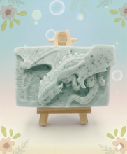 Load image into Gallery viewer, Dragon gift. Dinosaur gift. Our Flying Dragon soap features a striking dragon with its majestic wings spread wide, symbolising freedom and power. This artisan bar is vegan, cruelty-free, and designed with care for both your skin and the planet. Available in your choice of colour and essential oil. Each soap comes beautifully wrapped in eco friendly packaging. zero waste gift. kodern gift ideas. handmade home style. eco conscious home. eco friendly gifts. go green home.