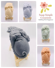 Load image into Gallery viewer, Dinosaur Gift | dinosaur Lover Gift | dragon Lover Gift | alternative Gift | Dragon & Egg Vegan Soap Check out this majestic dragon guarding a mysterious, enchanting egg – all captured in a luxurious bar of soap! Vegan, cruelty-free, and elegantly wrapped in eco-friendly packaging. All our soaps are made with natural clays and essential oils to gently cleanse and nourish your skin. Plus, they come in eco-friendly packaging so you can feel good. modern gifts. handmade home style. modern gifts.