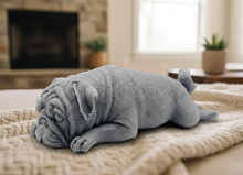 Load image into Gallery viewer, handmade vegan soap in the shape of a realistic sleeping pug dog lying flat, showing detailed wrinkles and fur texture, displayed in a spa-like setting with a candle and lavender.