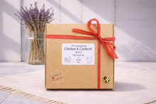 Load image into Gallery viewer, Gift box with a red ribbon and a label on a light wooden surface.