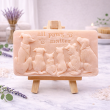 Load image into Gallery viewer, handmade vegan soap featuring a detailed 3D relief of various dog breeds sitting in a row with the text "all paws matter," displayed on a wooden easel against a rustic farmhouse decor background.