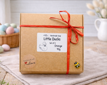 Load image into Gallery viewer, Gift box with 'Little Ducks' label and red ribbon on a wooden surface.