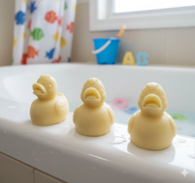 Load image into Gallery viewer, Three handmade vegan soaps in the shape of fluffy ducklings with open beaks, displayed on a neutral linen cloth in a bright farmhouse decor setting with Easter eggs in the background.