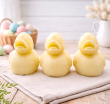 Load image into Gallery viewer, Three handmade vegan soaps in the shape of fluffy ducklings with open beaks, displayed on a neutral linen cloth in a bright farmhouse decor setting with Easter eggs in the background.