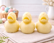 Load image into Gallery viewer, Three handmade vegan soaps in the shape of fluffy ducklings with open beaks, displayed on a neutral linen cloth in a bright farmhouse decor setting with Easter eggs in the background.