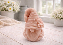 Load image into Gallery viewer, handmade vegan soap in the shape of a garden gnome sculpture with a long beard and a tall hat adorned with a large rose, displayed on a rustic white wooden surface in a bright farmhouse decor setting.