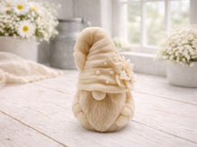 Load image into Gallery viewer, handmade vegan soap in the shape of a garden gnome sculpture with a long beard and a tall hat adorned with a large rose, displayed on a rustic white wooden surface in a bright farmhouse decor setting.