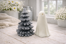 Load image into Gallery viewer, handmade ghost soap standing next to a grey textured Christmas tree sculpture soap, displayed on a rustic white wooden surface in a bright farmhouse decor setting.