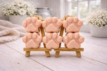 Load image into Gallery viewer, Set of pink paw-shaped vegan hand soaps on a wooden stand with a blurred indoor background.