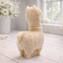 Load image into Gallery viewer, handmade vegan soap in the shape of a realistic standing alpaca or llama sculpture, featuring a smooth body with detailed fur texture on the head and neck, displayed in a bright farmhouse decor setting.