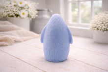 Load image into Gallery viewer, handmade vegan soap in the shape of a realistic young penguin sculpture, featuring a soft downy fur texture and a gentle expression, displayed in a bright farmhouse decor setting.