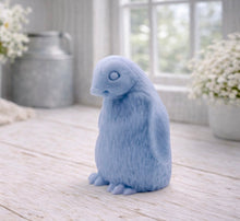 Load image into Gallery viewer, handmade vegan soap in the shape of a realistic young penguin sculpture, featuring a soft downy fur texture and a gentle expression, displayed in a bright farmhouse decor setting.