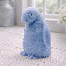 Load image into Gallery viewer, handmade vegan soap in the shape of a realistic young penguin sculpture, featuring a soft downy fur texture and a gentle expression, displayed in a bright farmhouse decor setting.