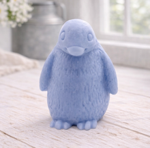 Load image into Gallery viewer, handmade vegan soap in the shape of a realistic young penguin sculpture, featuring a soft downy fur texture and a gentle expression, displayed in a bright farmhouse decor setting.
