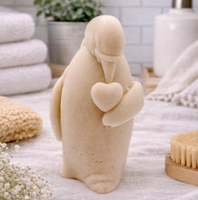Load image into Gallery viewer, handmade vegan soap in the shape of a realistic penguin sculpture holding a small heart to its chest,